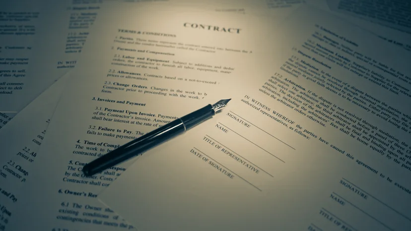 A fountain pen on a contract and signature page, illustrating contract notification