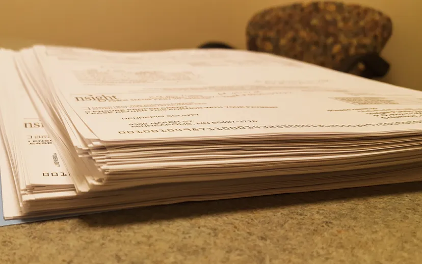 A folder holding a thick stack of printed documents
