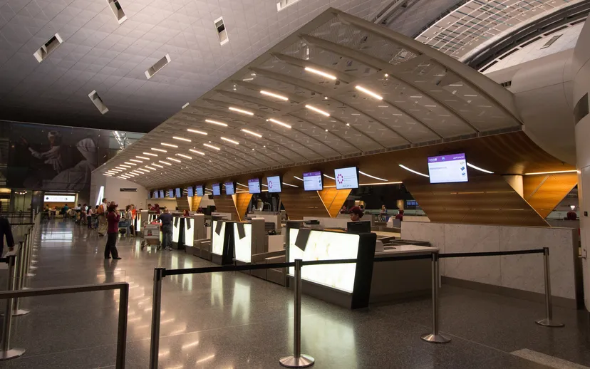 The long check-in hall at Hamad International Airport in Doha with its curved wooden ceiling.