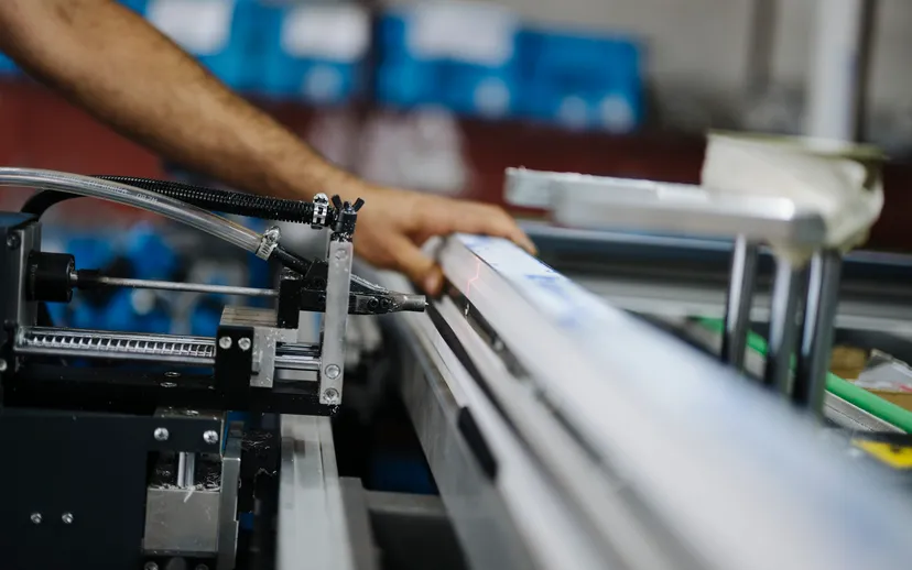 A worker assembling metal parts on factory machinery