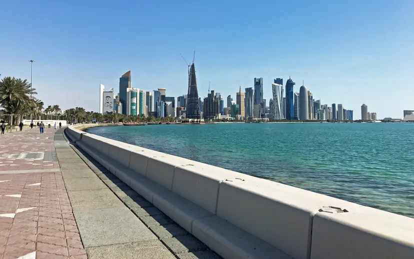 The Doha Corniche promenade runs along the bay towards the West Bay towers on a clear day.