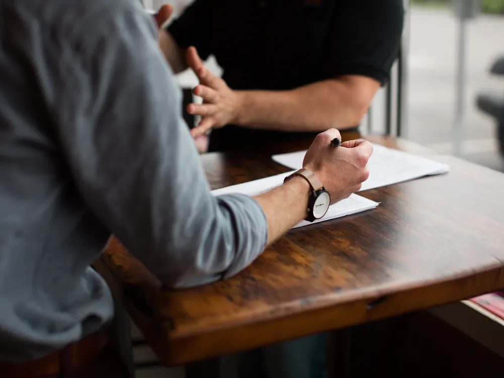 Two people going through papers together at a table