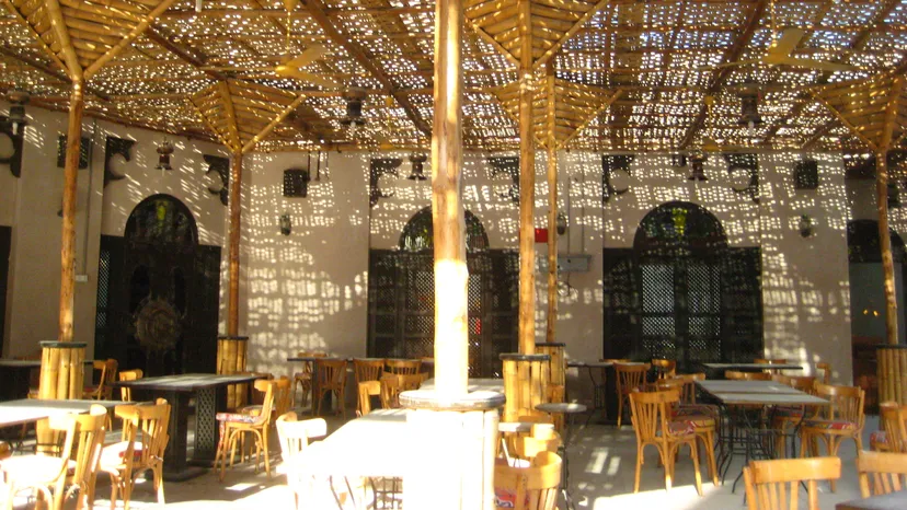 Inside the Khan Farouk café in Souq Waqif, Doha, with tables under a woven roof