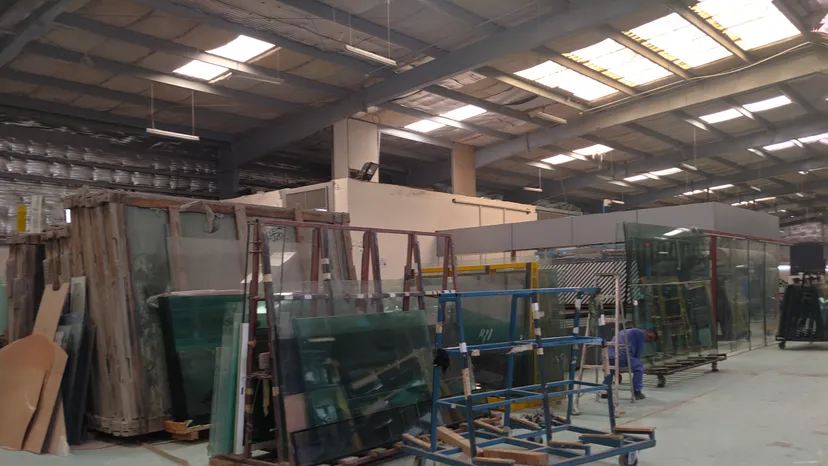 Inside a glass factory in Doha Industrial Area, with glass sheets on racks