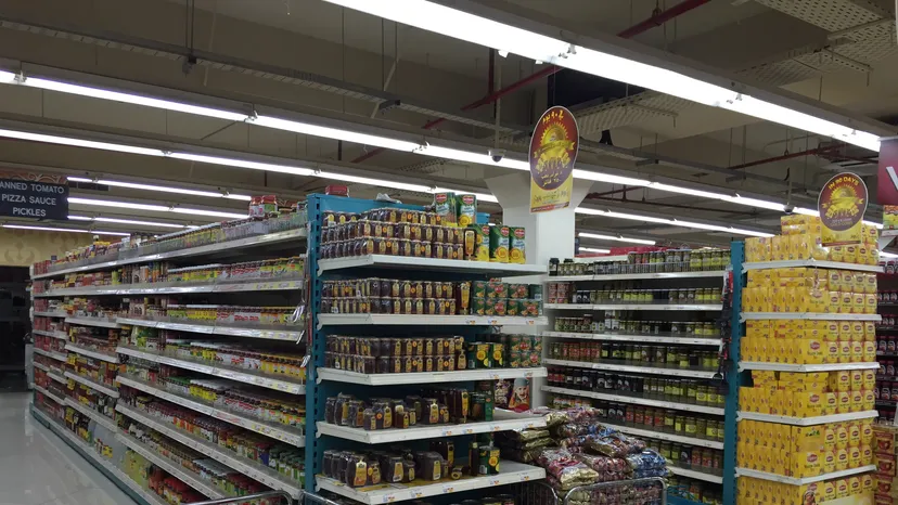 A hypermarket aisle in Doha with shelves of packaged goods and promotion signs